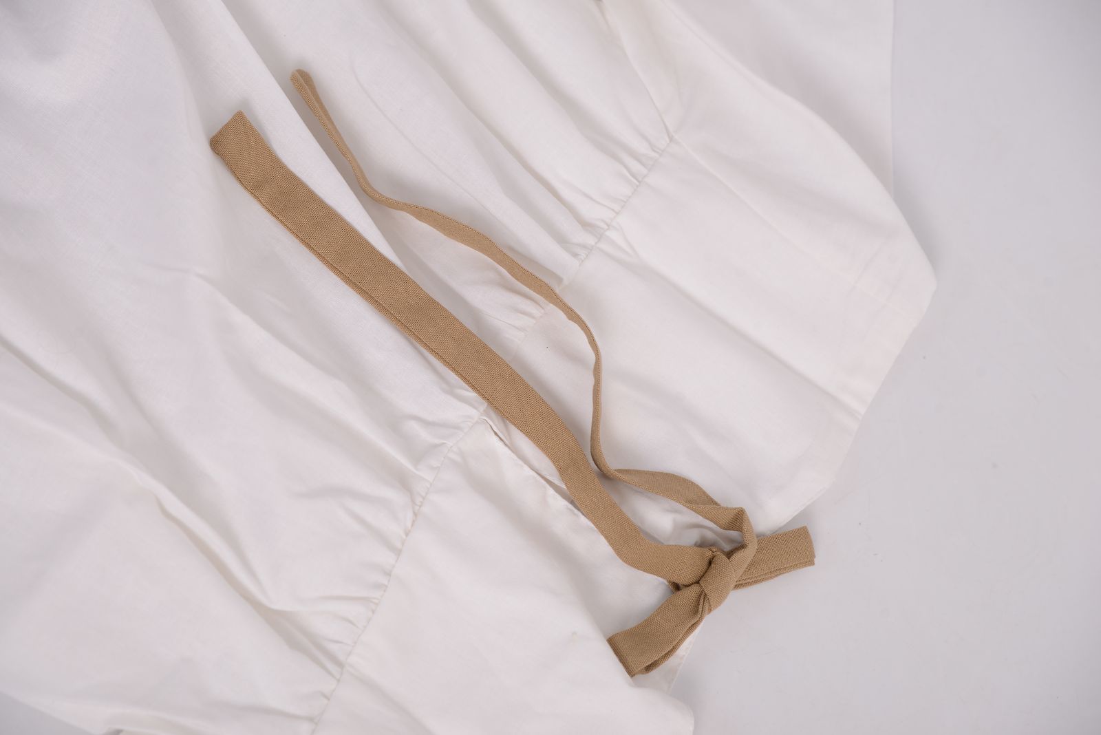 Détail du lien noué dans le dos d’une blouse blanche